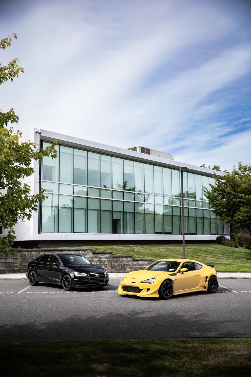 Mercedes E55 AMG and widebody Toyota 86 outside a modern glass building