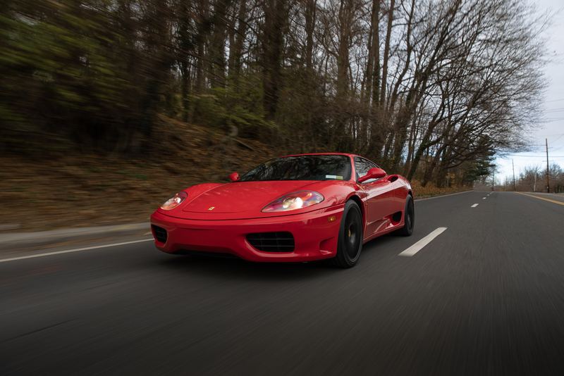 Red Ferrari 360 Modena rolling shot on an open road