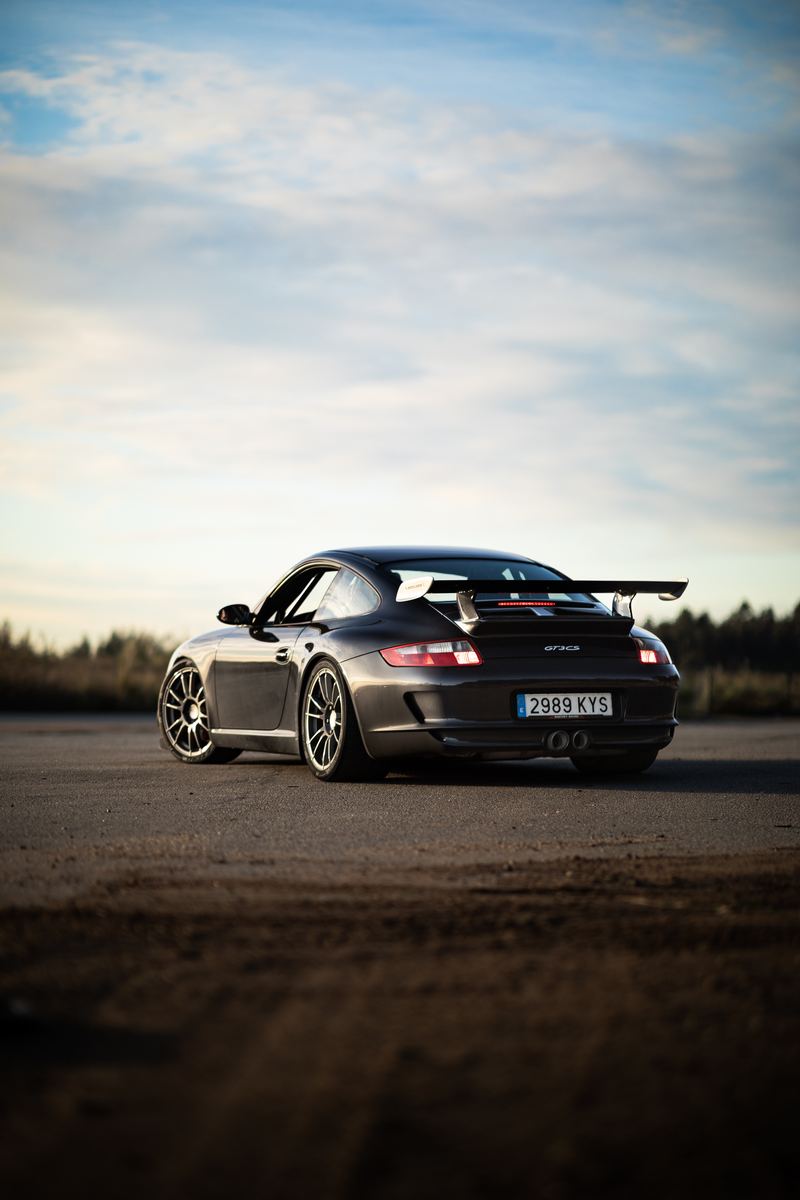 Porsche 911 GT3 rear wing against a sunset sky