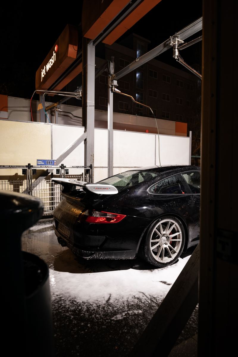 Porsche 911 GT3 under the wash bay lights at night