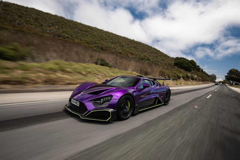 Purple widebody hypercar at speed on a mountain road