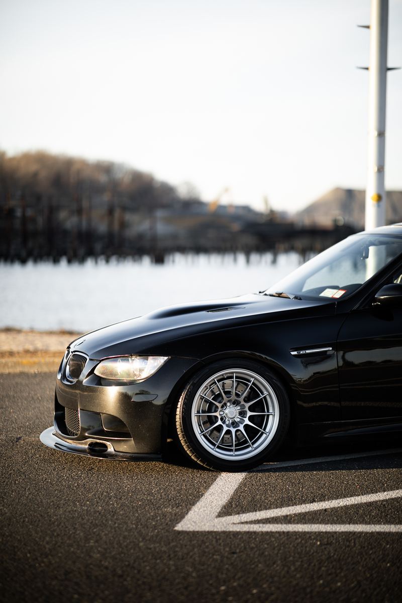 Black BMW M3 on polished wheels by the waterfront
