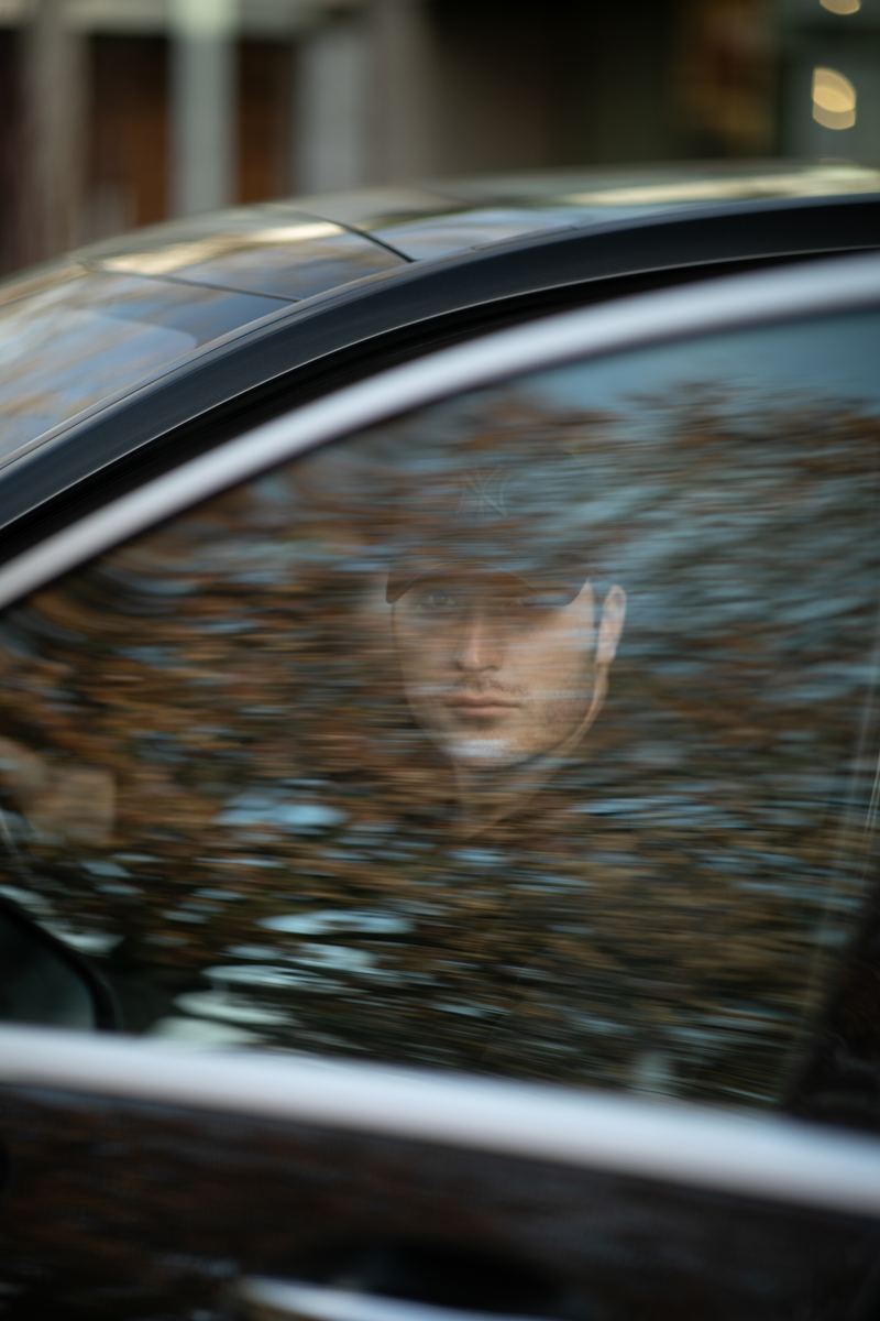 Photographer reflected in a car window mid-rolling-shot