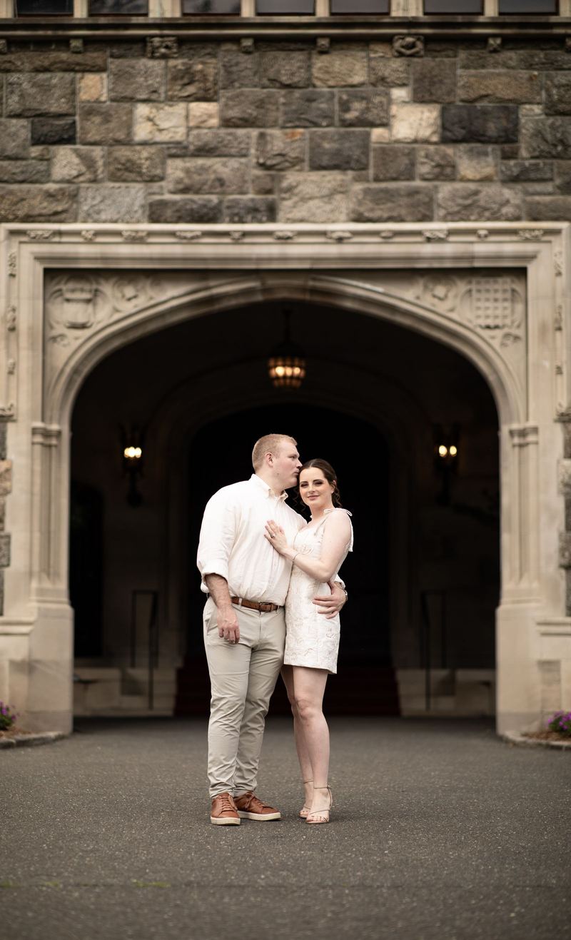 Couple embracing beneath a stone castle archway