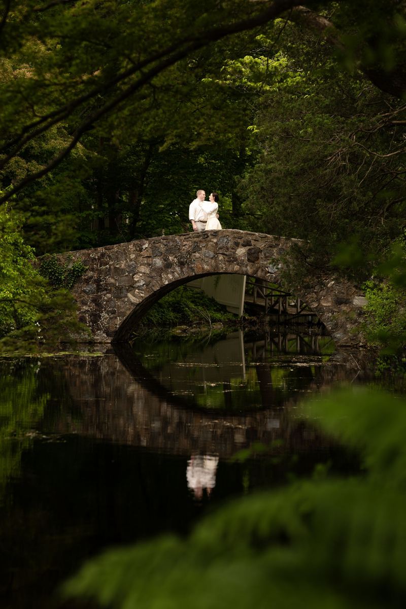 Engagement photography in NY: couple on a stone bridge over still water