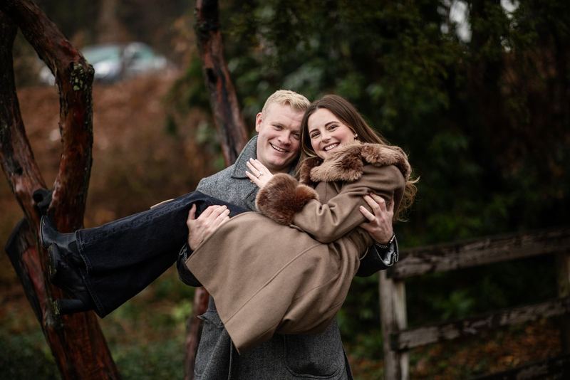 He carries her in his arms, both laughing