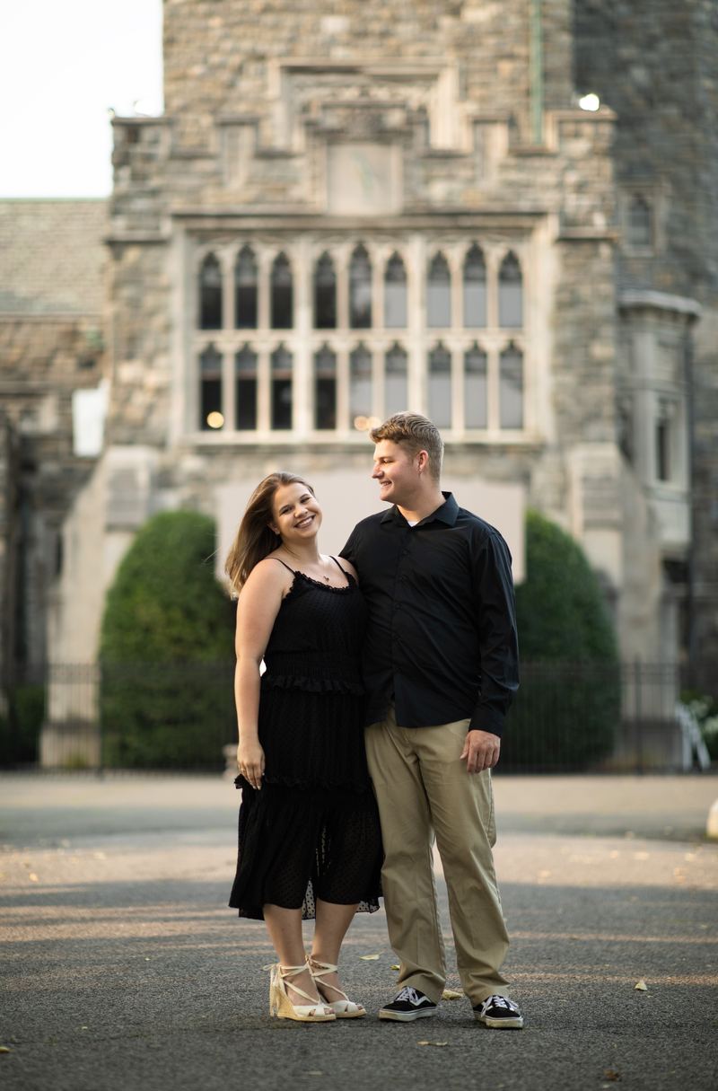 Couple in evening black outside a gothic stone mansion