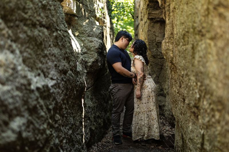 Couple stealing a kiss between rock walls