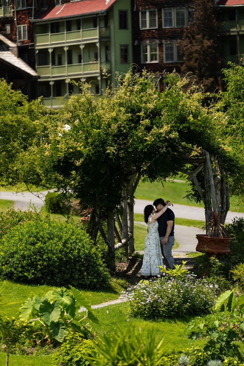 Couple kissing beneath a garden arbor at a mountain resort