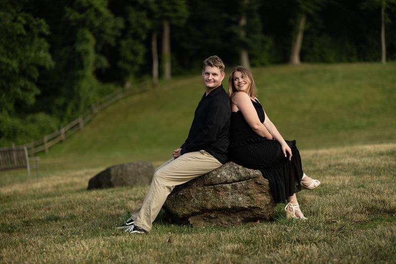 Couple seated together on a boulder in evening light