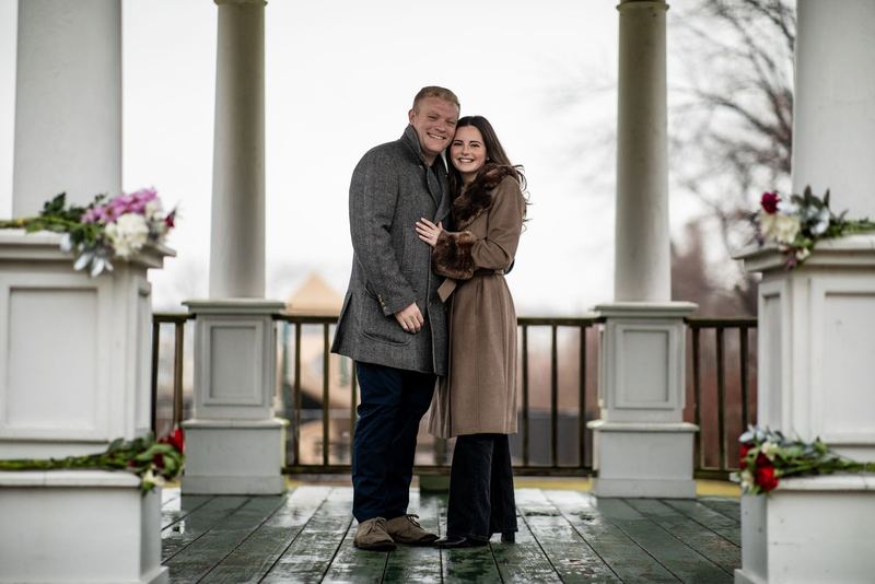 Couple bundled up on a flower-lined winter porch