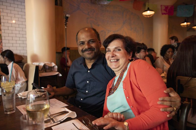 Couple sharing a smile over dinner at a lively restaurant