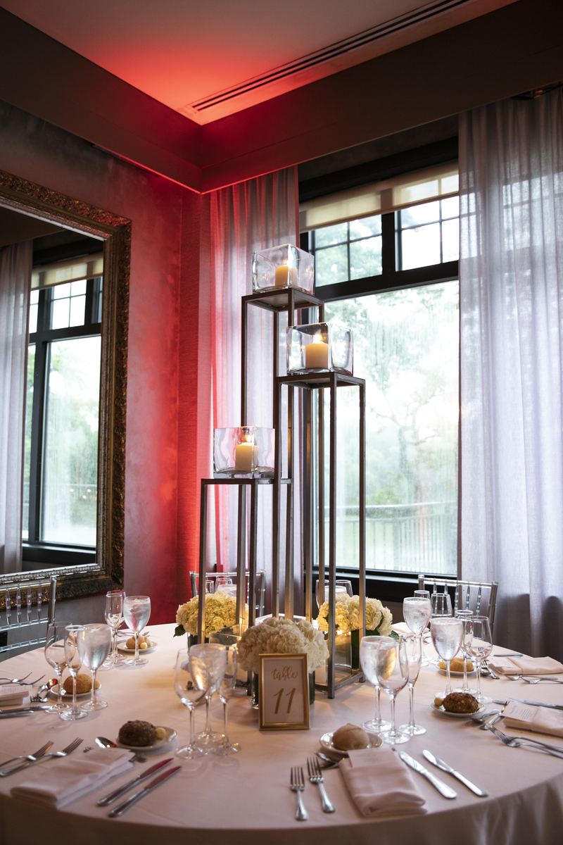 Red-lit reception table detail with candles and florals