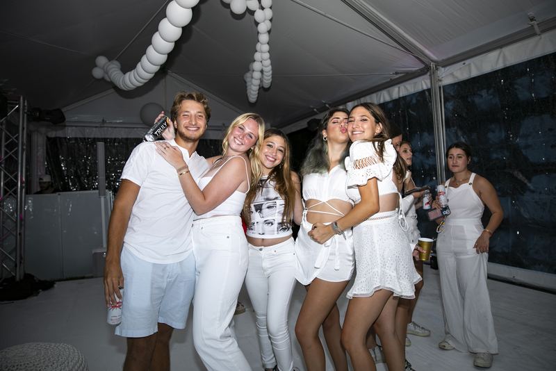 Group of friends celebrating at an all-white party